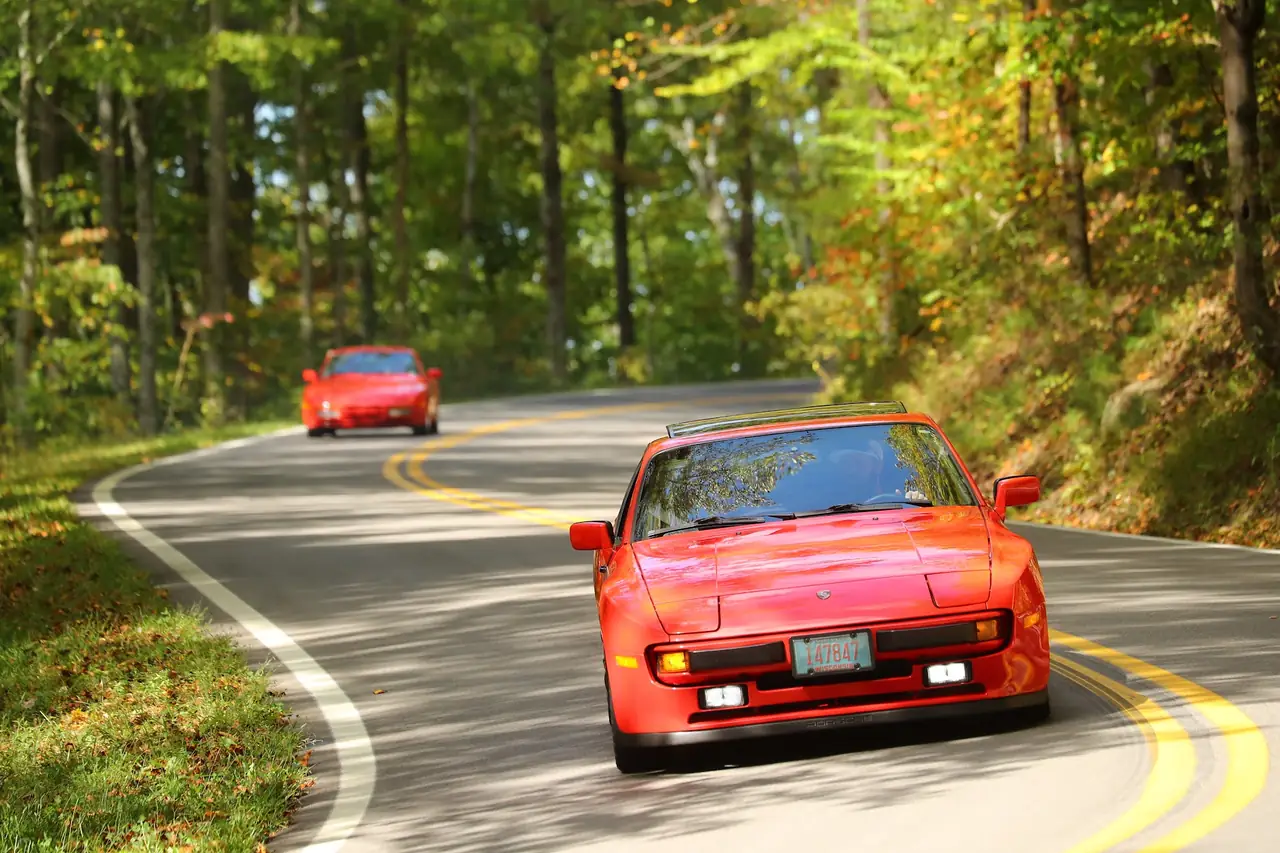 A red 944 rounding a curve with another close behind